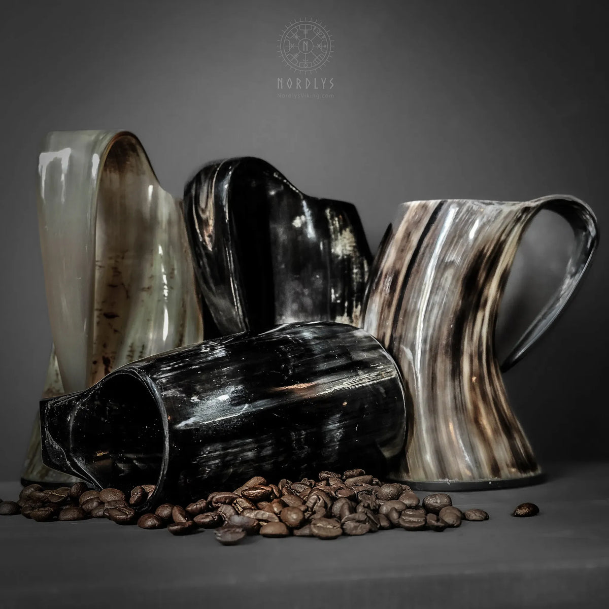 Fyra stora hornkaffemuggar blandad färg med kaffebönor.