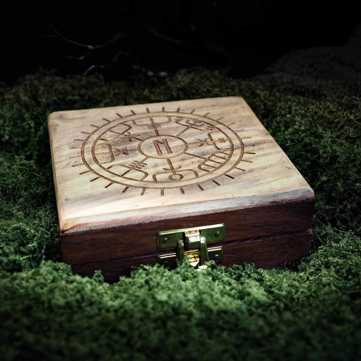 Träask med graverad Vegvisir-symbol på locket på mossgrön bakgrund