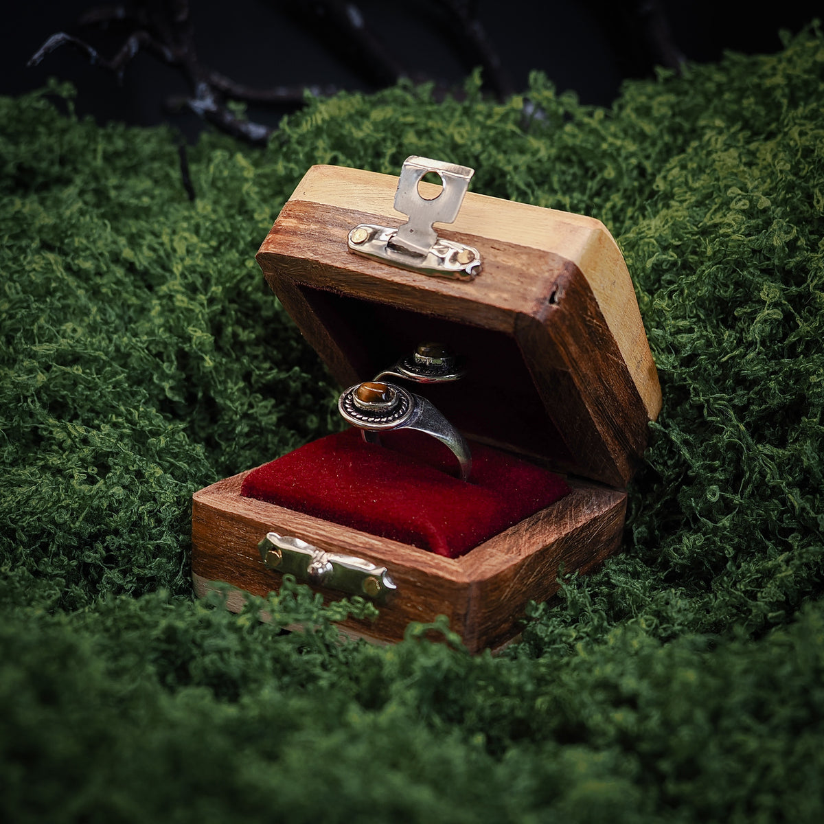 Liten nordlys presentask i trä med röd sammetsfoder och metallklamra, öppen för att visa innehåll