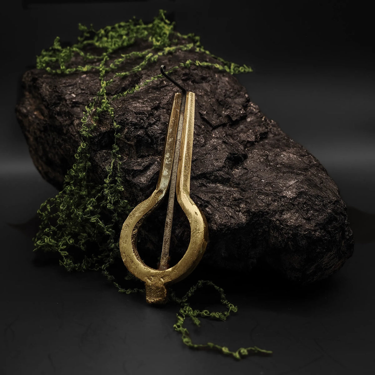 Mungiga traditionell stämd variant i mässing med guld-bronsglans på naturlig stenig miljö