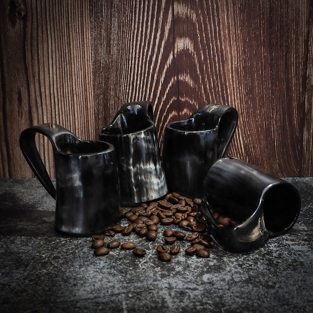 Sæt med fire espressokopper – alle fire kopper med kaffebønner, mod trævæg