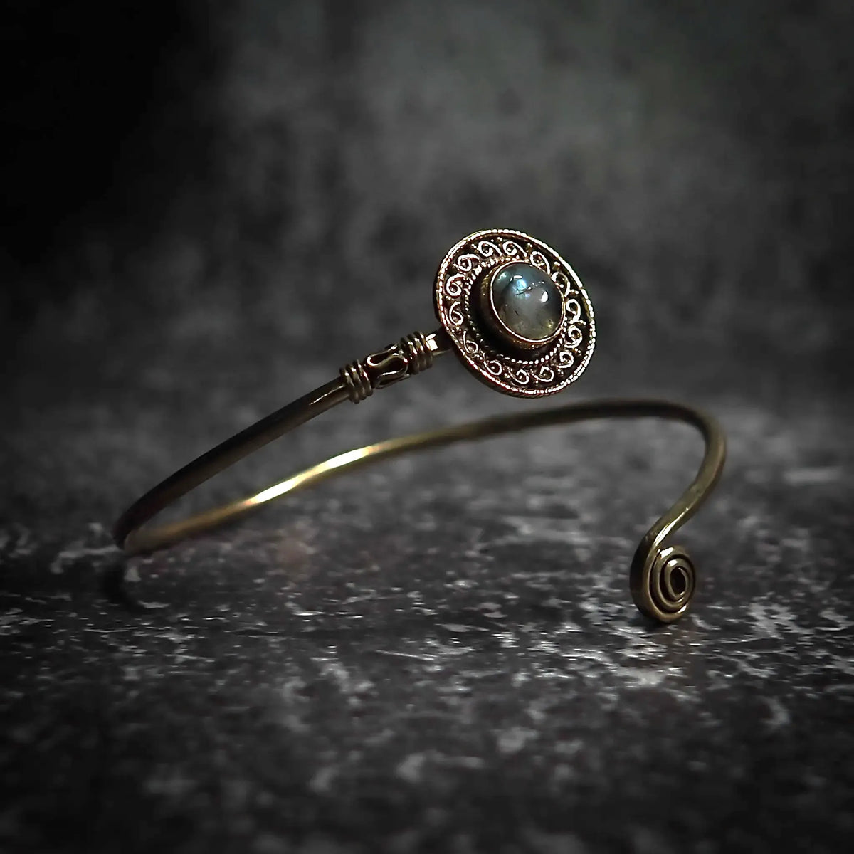 Justerbart sköld-armband med labradorit halvädelsten, dekorativ mässingornamentik och filigrerat mönster.