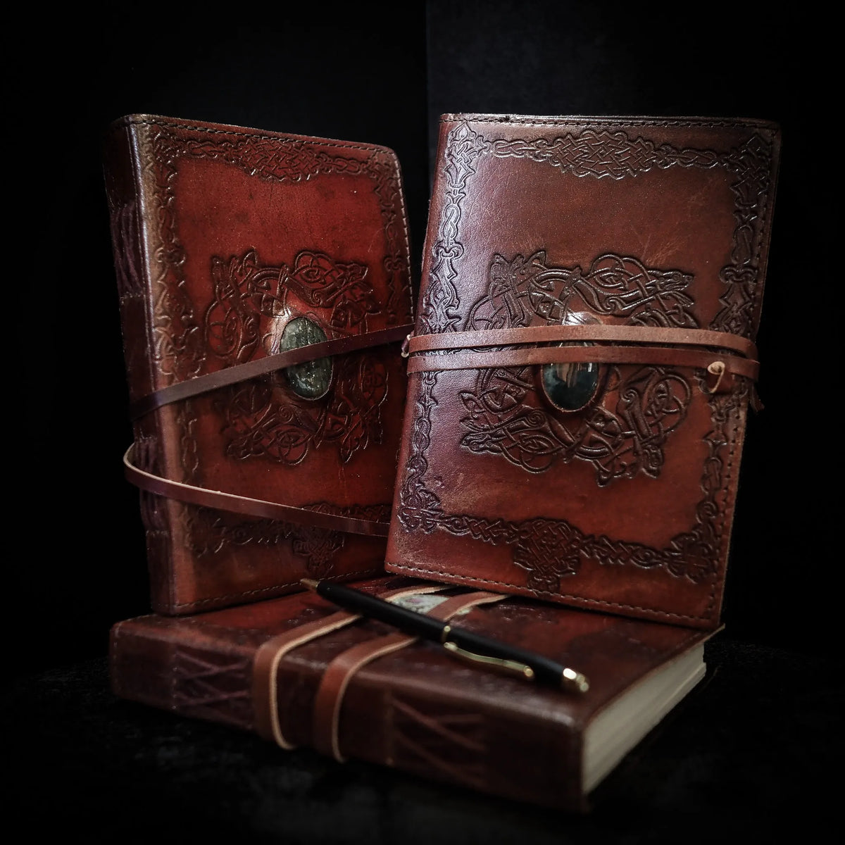 Tre håndlavede læderbøger Krystal i medium størrelse med mos-agat-sten. Burgunderbrunt læder med præget vikingedekor, hver bog har en grøn mos-agat-sten i metalfatning og brunt læderbånd.
