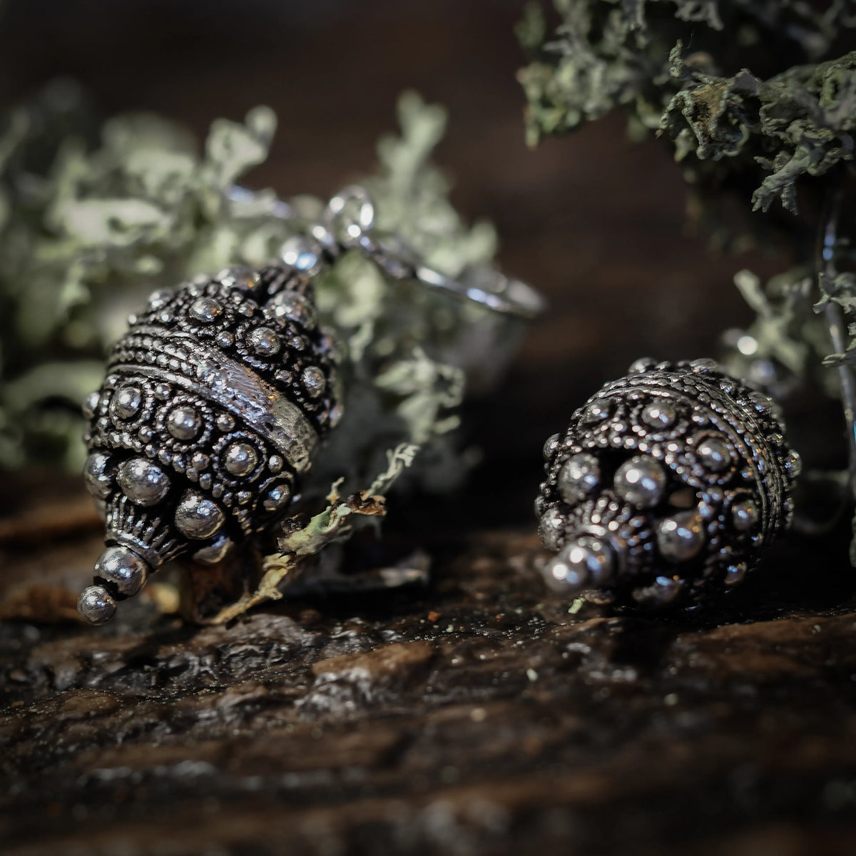 Örhänge Filligran, örhängen visade på mörk bakgrund. Arbetet är detaljerat.