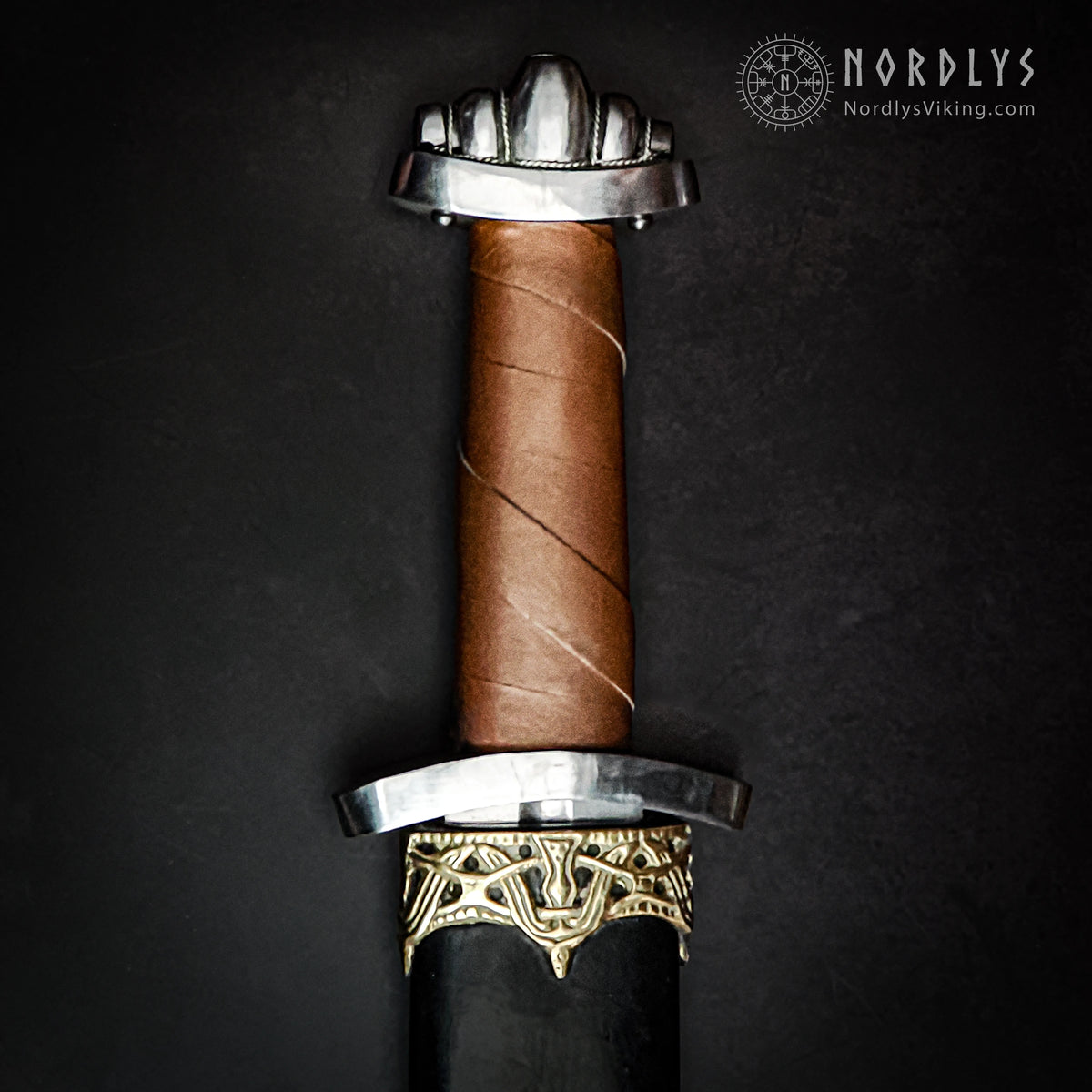 Vikingasvärd med femlobad pommel av silver och lädergreppet. Professionell produktfoto från Nordlys Viking.