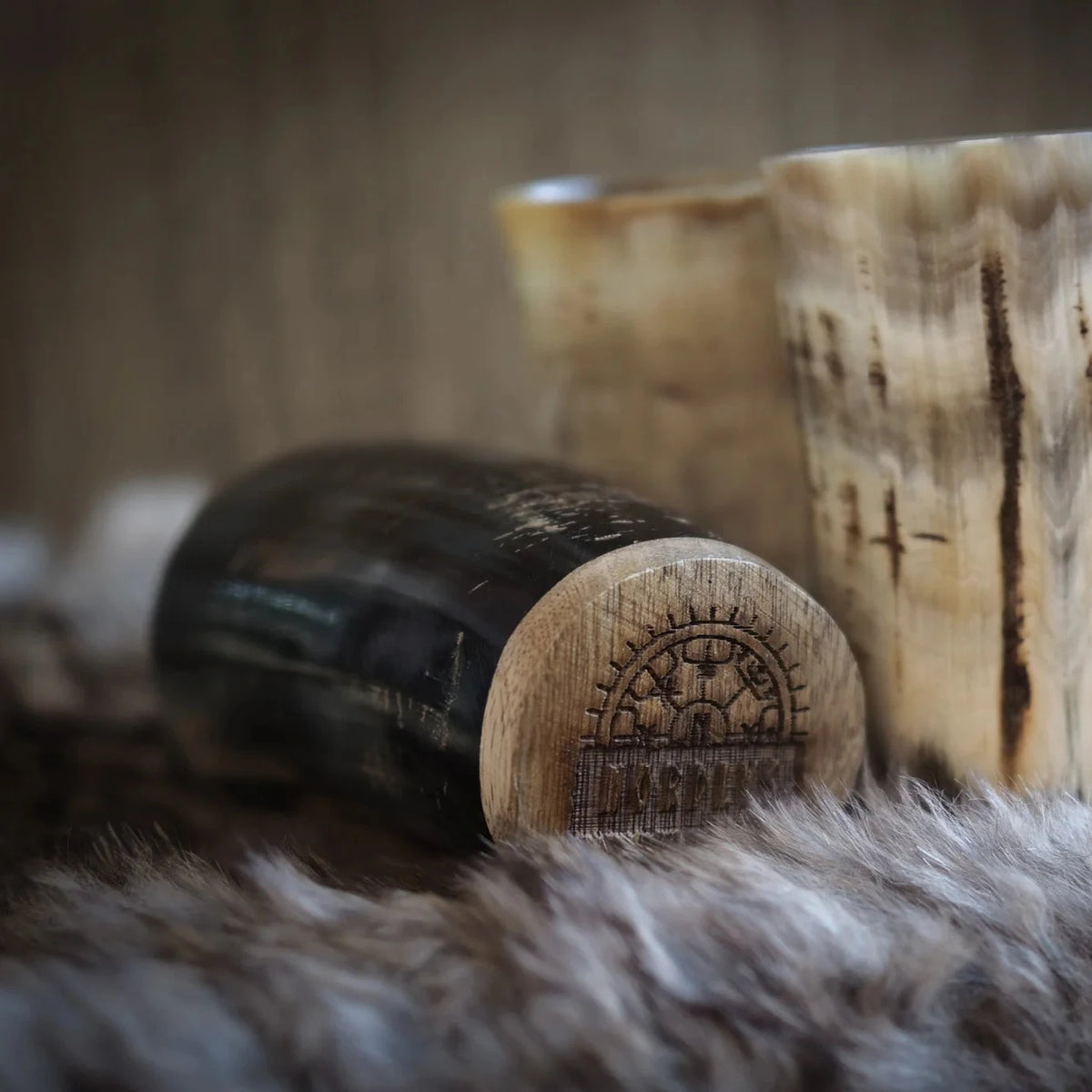 Detaljer på hornkopp med träbotten, visar graverad vikingtmarkering på basen, närbilder.