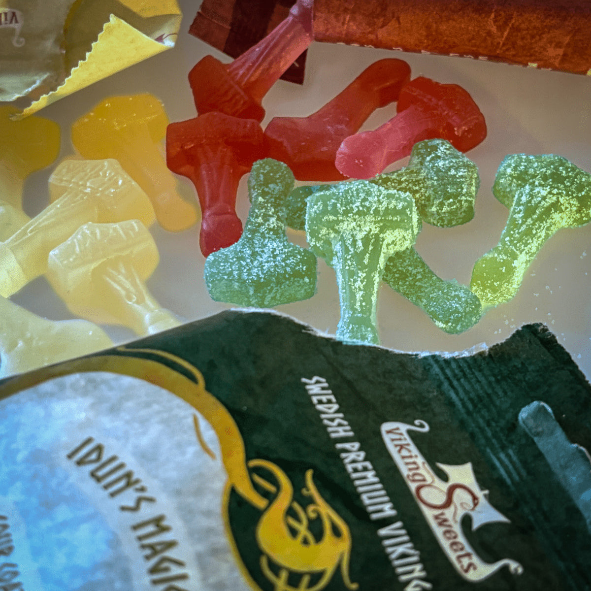 Colorful sweet Mjolnir candies arranged to show elderflower (yellow), raspberry (red) and sour apple (green) flavors