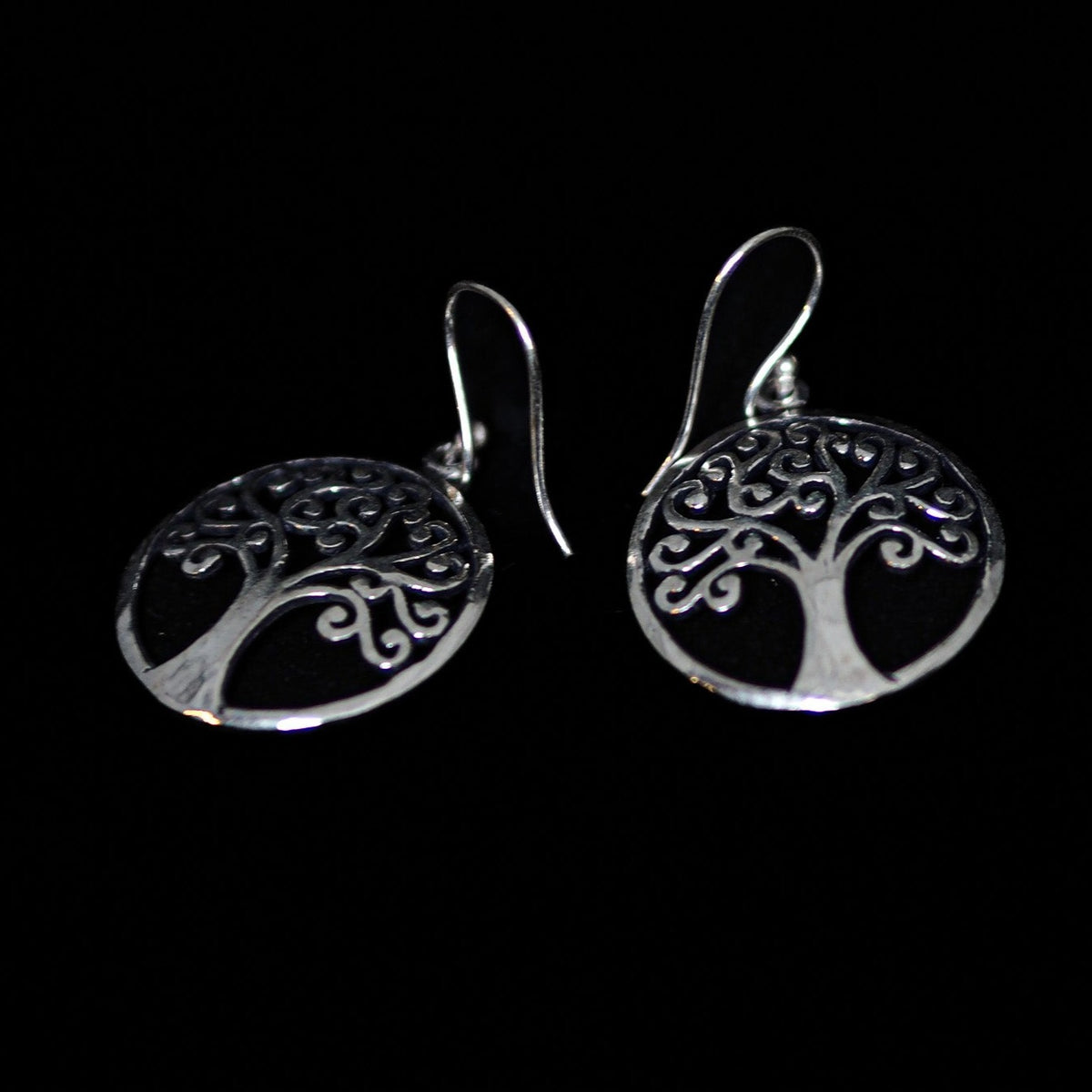 Silverfärgade Tree of Life hängörhängen med ornament träd- och rotmotiv på svart bakgrund