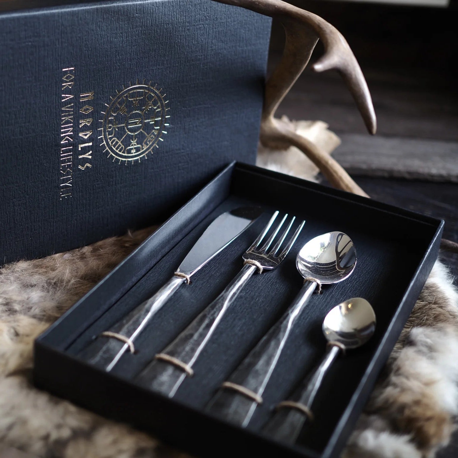 Premiumbestickset i rostfritt stål med hammrat handsmide i svart presentask med vikingruner och 'NORDLYS - FOR A VIKING LIFESTYLE' text