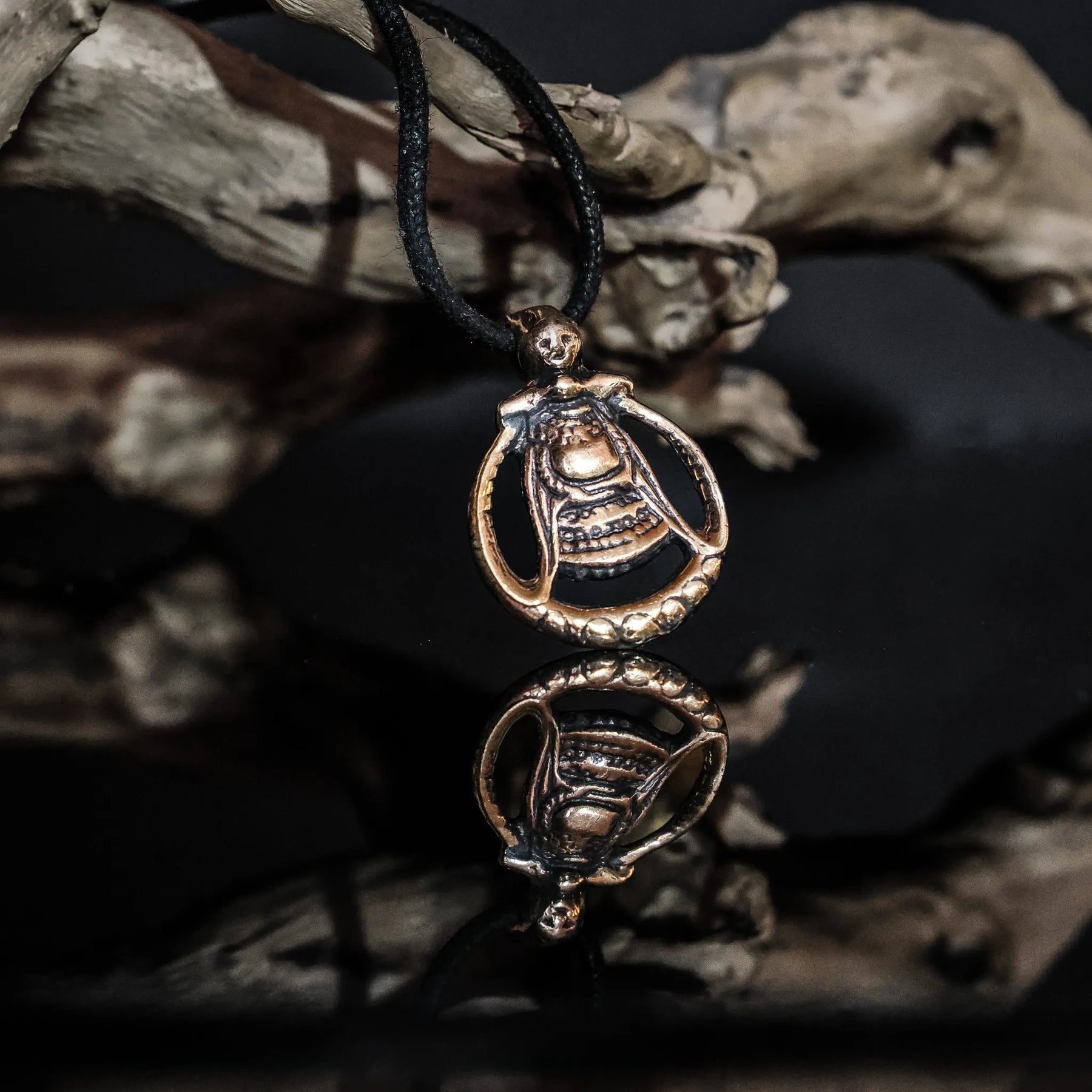 Bronsad Frejasmycke hängande på svart läderrem med traditionell vikingadesign, framkallande gudinnans figur med detaljerad utsmyckning