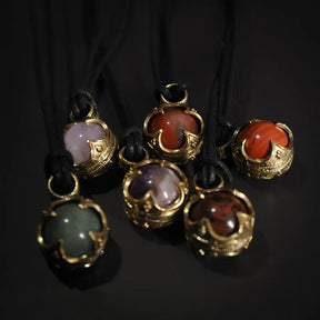 Sex Gotlandshängen med mässingsinfattning och olika färgade halvädla stenar: ametist, karnelsten och rökt kvarts på svart lädersnöre