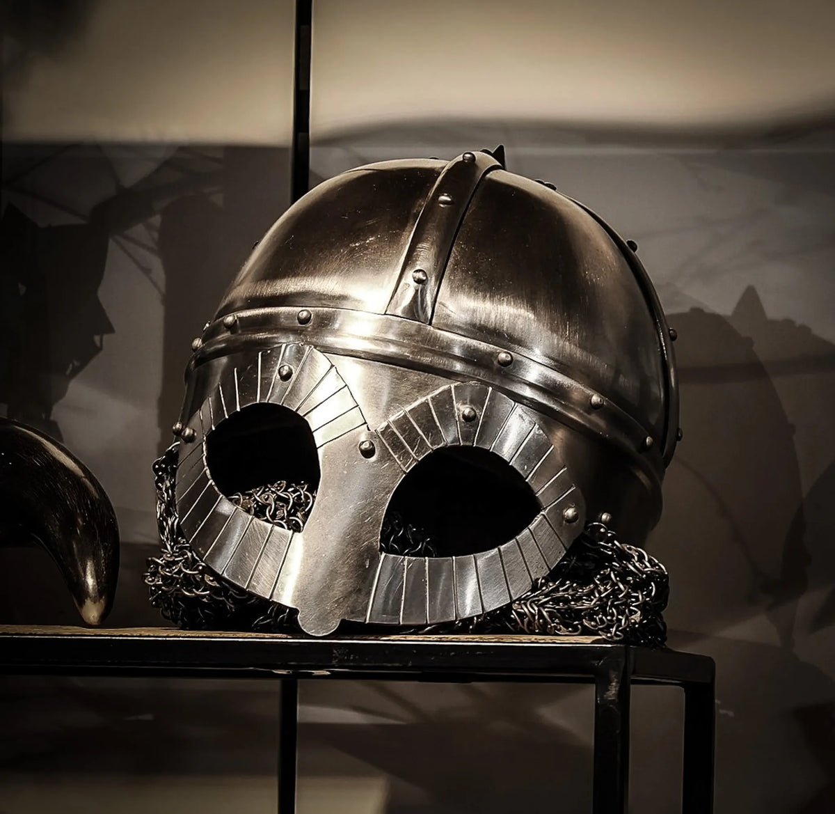 Gjermundbu vikingahjälm i stål med brons-kindskydd och läderföring, studiobelyst