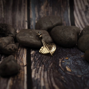 Bronshänge i form av vikingaskepp på träyta. Detaljerad drakehuvud och skeppskrov i metallform med varm glans.