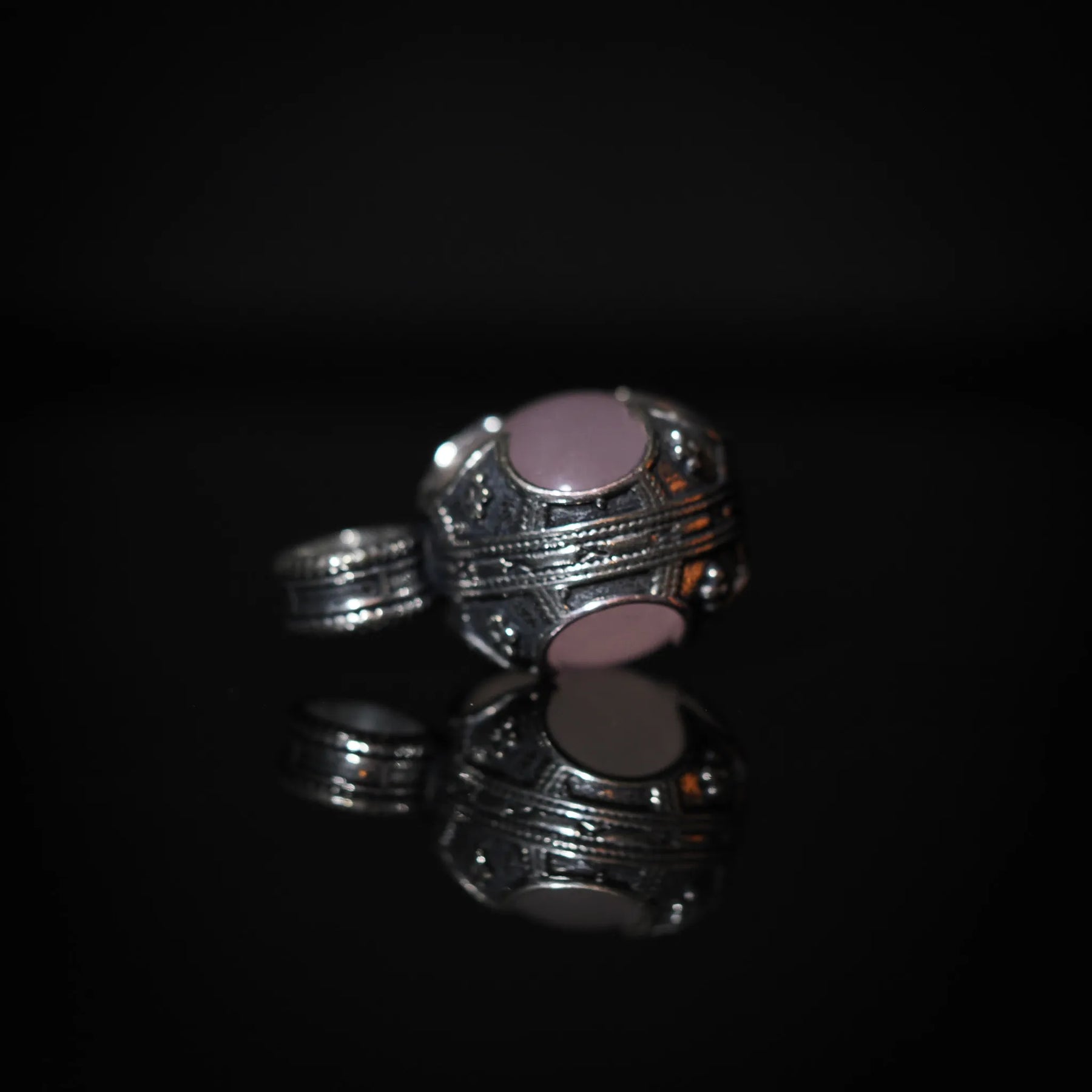 Gotlandshänge-hänge, överblicksbild som visar det fullständiga fyrklöver-designade mässingsramverket med rosa kvarts i centrum. Visar symmetrisk vikinginspirerad metallteknik.