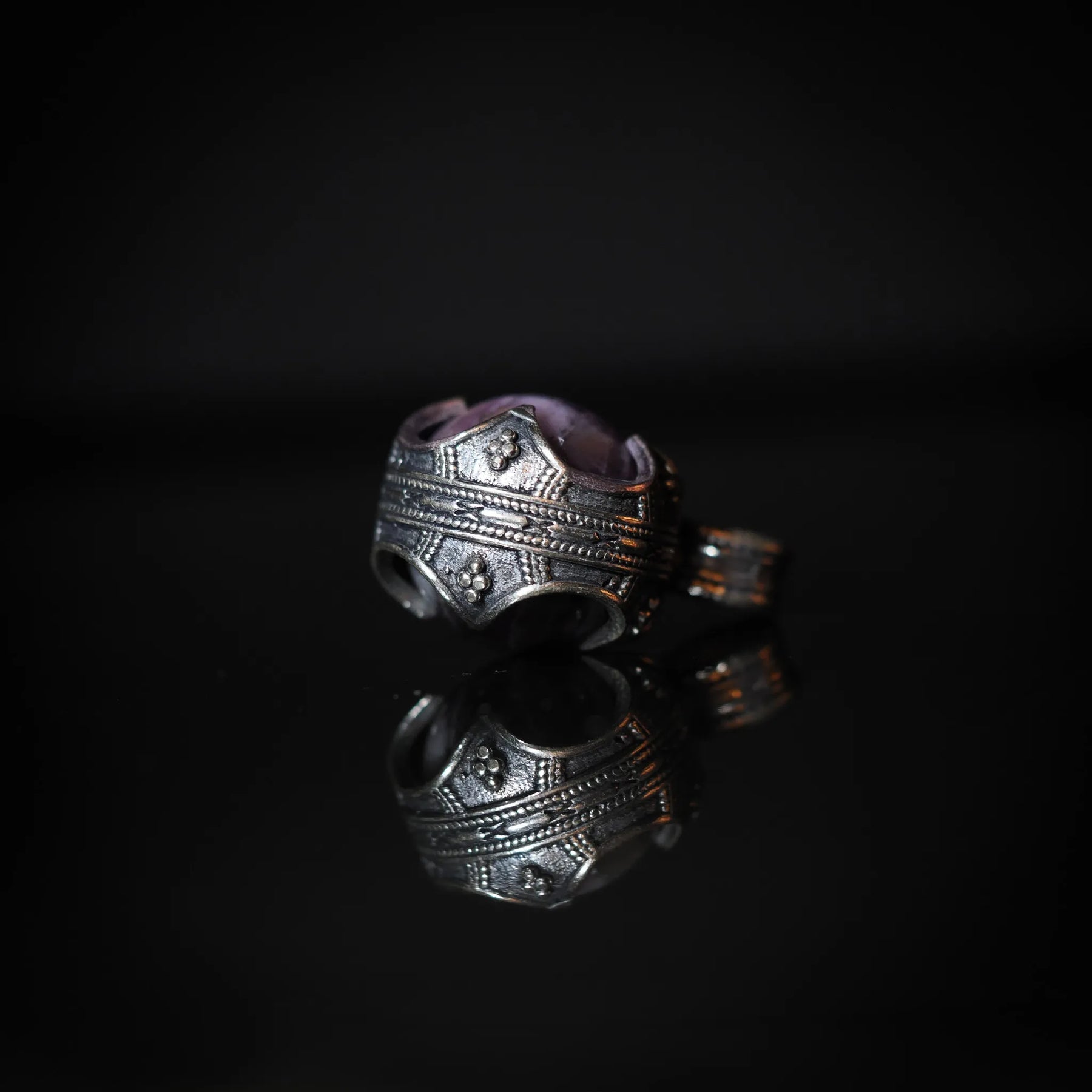 Närbild på silverpläterad mässingram med filigréarbete och prickmönster, oxiderad finish