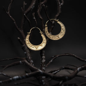 Stora månsymbolörhängen i mässing med filigranbordad kant på mörka grenar