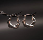 Par silverpläterade mässingsörhängen med flätmönster, ungefär 2cm