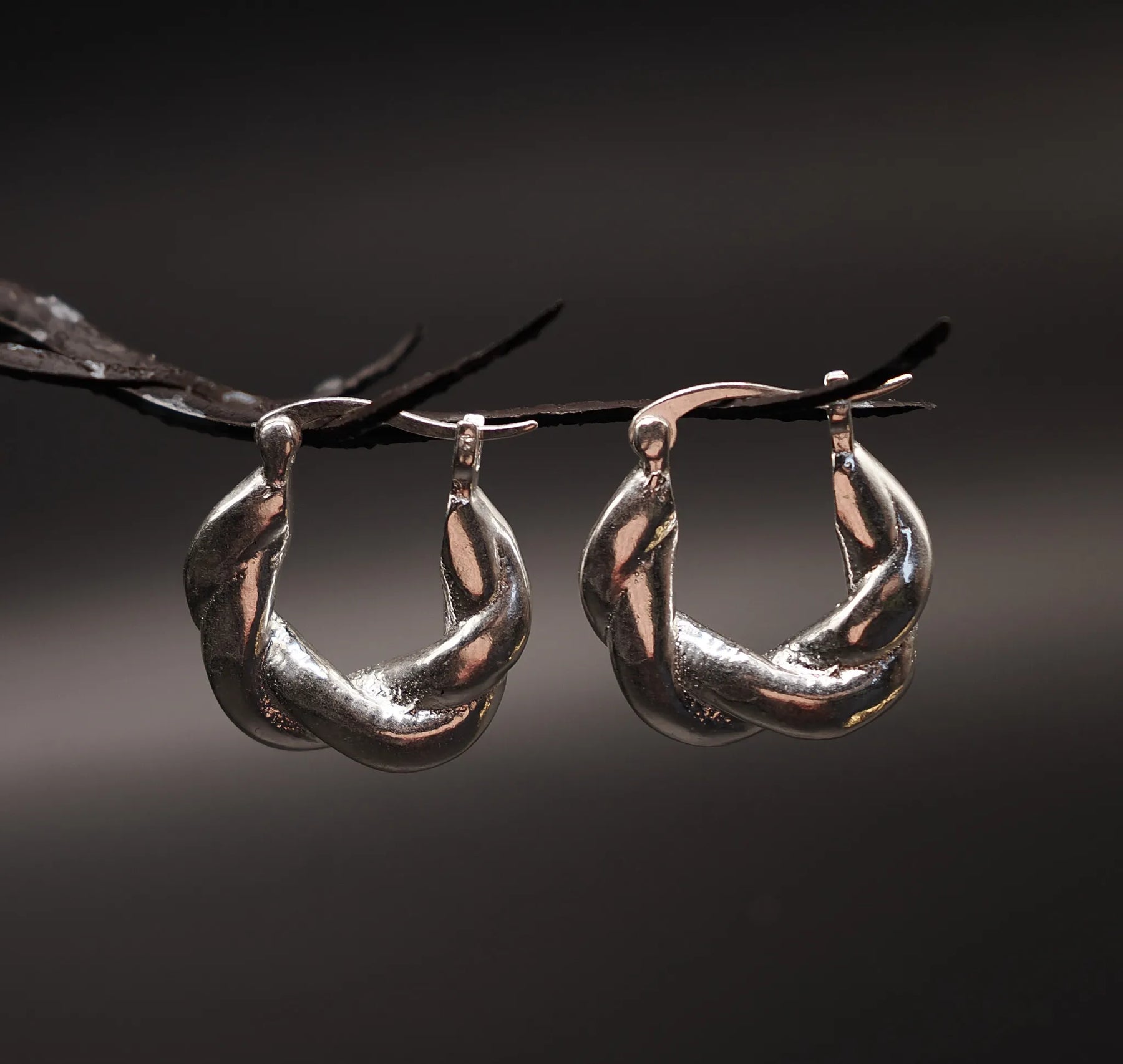 Par silverpläterade mässingsörhängen med flätmönster, ungefär 2cm