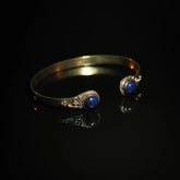 Mässingsarmband med två djupblå lapis lazuli-stenar med guldglitter i keltiska vikingafattningar