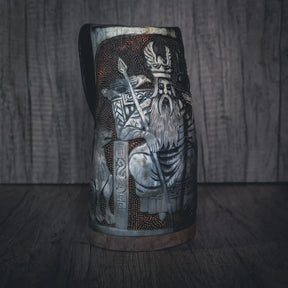 Handsnidad hornmugg med stor Odin-figur i högt relief. Stående krigarfigur med detaljerade kläder, långt skägg och hållande vad som verkar vara en stav eller spjut. Komplex komposition med Odin som centralfigur omgiven av ytterligare snidelement och mönster. Naturligt horn med utmärkt relief definition. Kopparband vid basen.