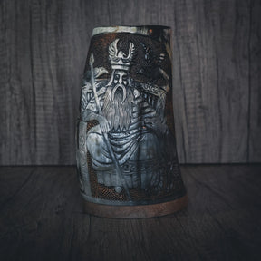 Handsnidad hornmugg med detaljerad gravering av Allfather Odin. Visar skäggig nordisk krigarfigur med hornad krona och rustningsdetaljer. Mässingsband skapar metallic accent. Djup engraving med fin linjearbete och naturligt hornmaterial.