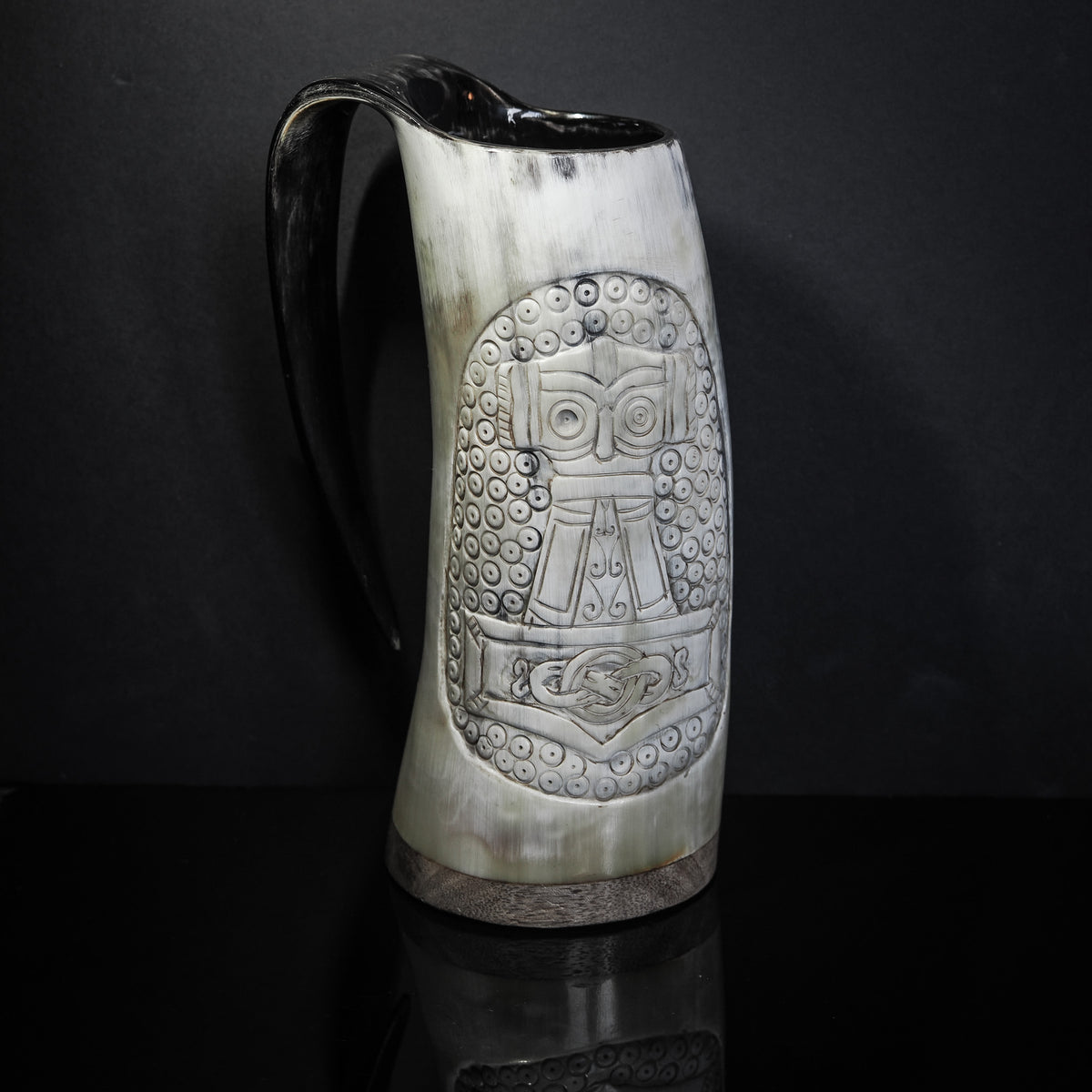 Handsnidad hornmugg i naturligt horn med svart läderhandtag. Framvy som visar detaljerad målning av Tors hammare (Mjölnir) omgiven av vikingtida knotverk och ornamentik på muggkroppen.