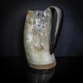 Hornmugg från tre-fjärdedelsvinkeln visar Torshammare-gravyr med mässing-handtag och naturlig hornfärg med beige-toner.