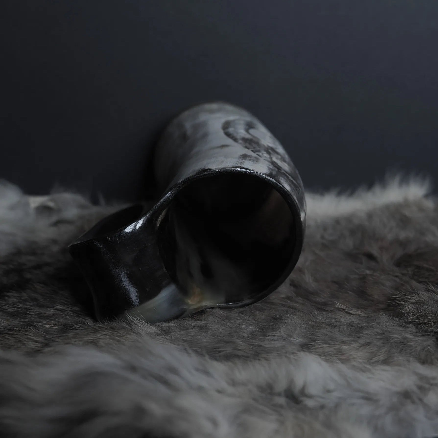 Överögonblicksvyn av hornmuggen visar den öppna mynningen och hur Tyr och Fenrir-motivet är karvat djupt in i hornets vägg med kedjebrynjatextur.