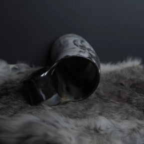 Överögonblicksvyn av hornmuggen visar den öppna mynningen och hur Tyr och Fenrir-motivet är karvat djupt in i hornets vägg med kedjebrynjatextur.