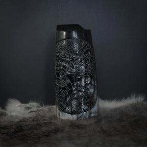 Framansicht av hornmugg med handsnidad Tyr och Fenris motif. Naturhorn med svart handtag. Studio-fotograferad på neutral bakgrund.