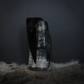 Hornmugg från tre-fjärdedels vinkel visar Tyr och Fenris sniderier med djup relief och ornamental prickmönster gräns.