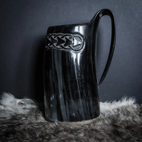 Hornmugg med detaljerad Livets träd-gravering i mitten. Rötterna sprider sig ned medan grenarna växer uppåt. Keltisk knut överst. Svart polerat horn med präglad design.