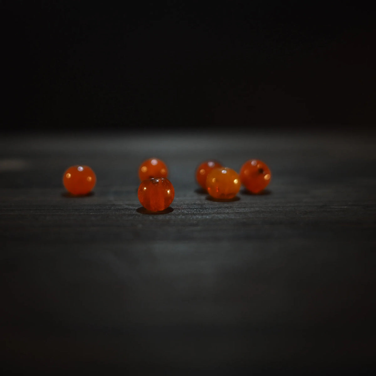 Runda orangeglas pärlor, 6mm, på träyta