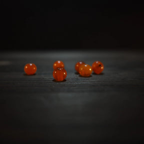 Runda orangeglas pärlor, 6mm, på träyta