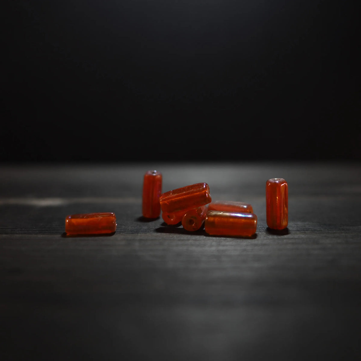 Längsgående orangeglas pärlor på grå bakgrund