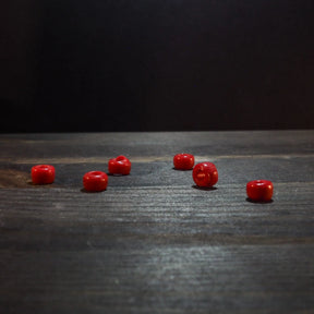 Red glass bead 5mm diameter, glossy finish, spherical shape, shown at actual size for reference