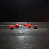 Rund röd glaspärla - Round red glass beads (6mm) on dark wood. Deep translucent ruby-red glass beads ideal for jewelry and craft beading projects.