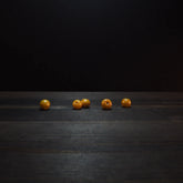 Golden yellow round glass beads, 6mm diameter, displaying polished finish and drilled holes for jewelry making