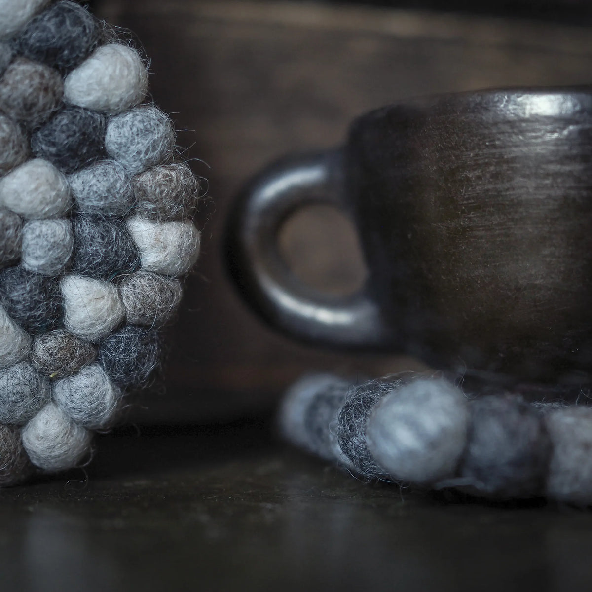 Närbild av runt filtrat underlägg med svart och vita ullkulor