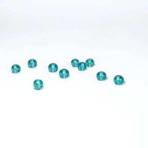 Ungefär 11 små turkosglaspärlor på vit yta