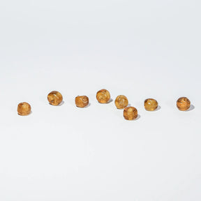 Rund orange glaspärla - Round orange glass beads (5mm) on light background. Warm amber translucent spheres for jewelry crafting and beading projects.