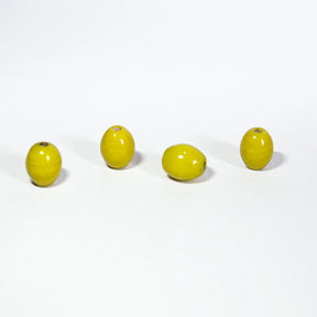 Fyra gula ovalglaspärlor, 7x10mm, på ljus bakgrund