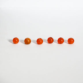 Runda orangeglas pärlor, 6mm, på ljus bakgrund