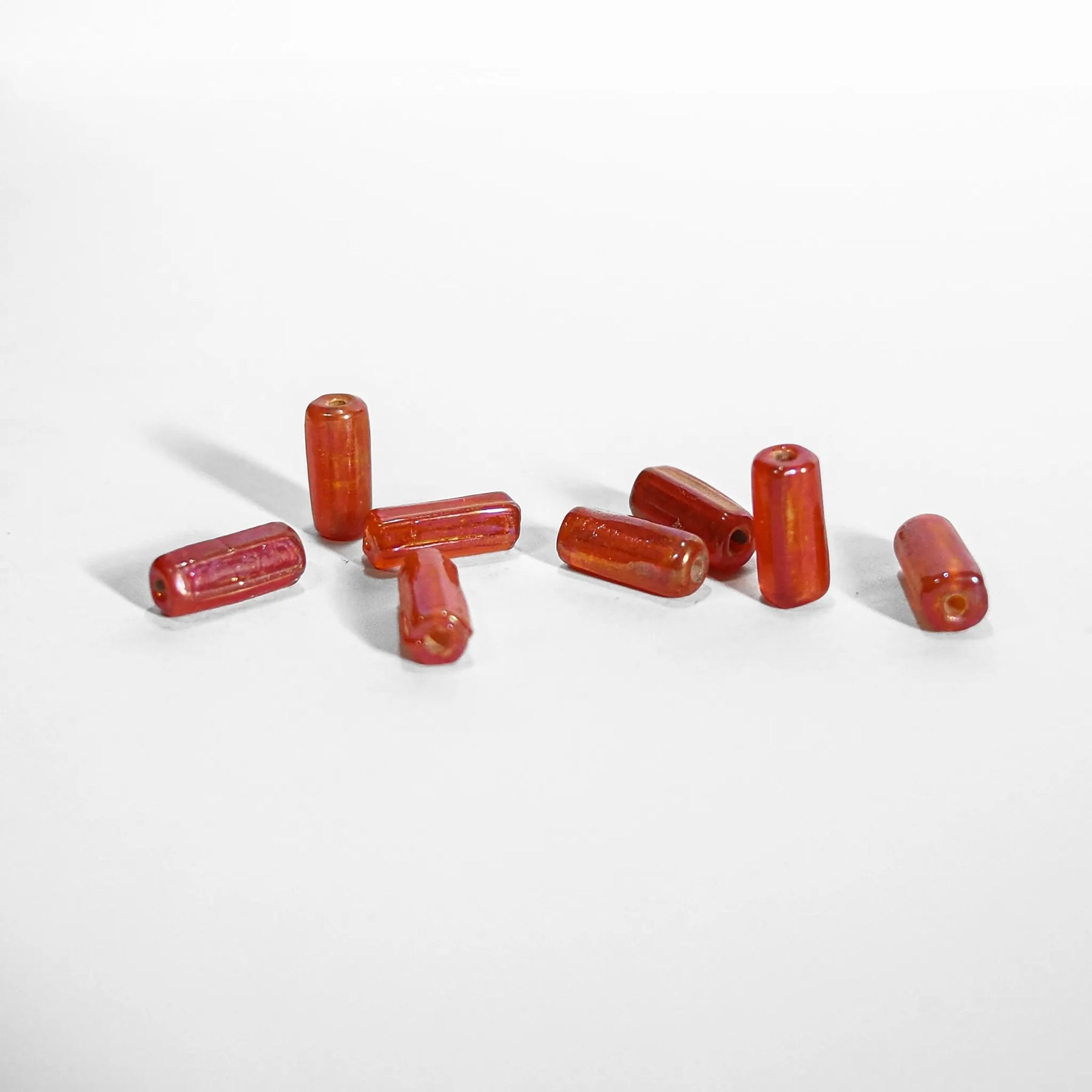 Orange glaspärla - elongated glass beads in translucent orange-red, approximately 1.5cm length, suitable for jewelry making and beading projects
