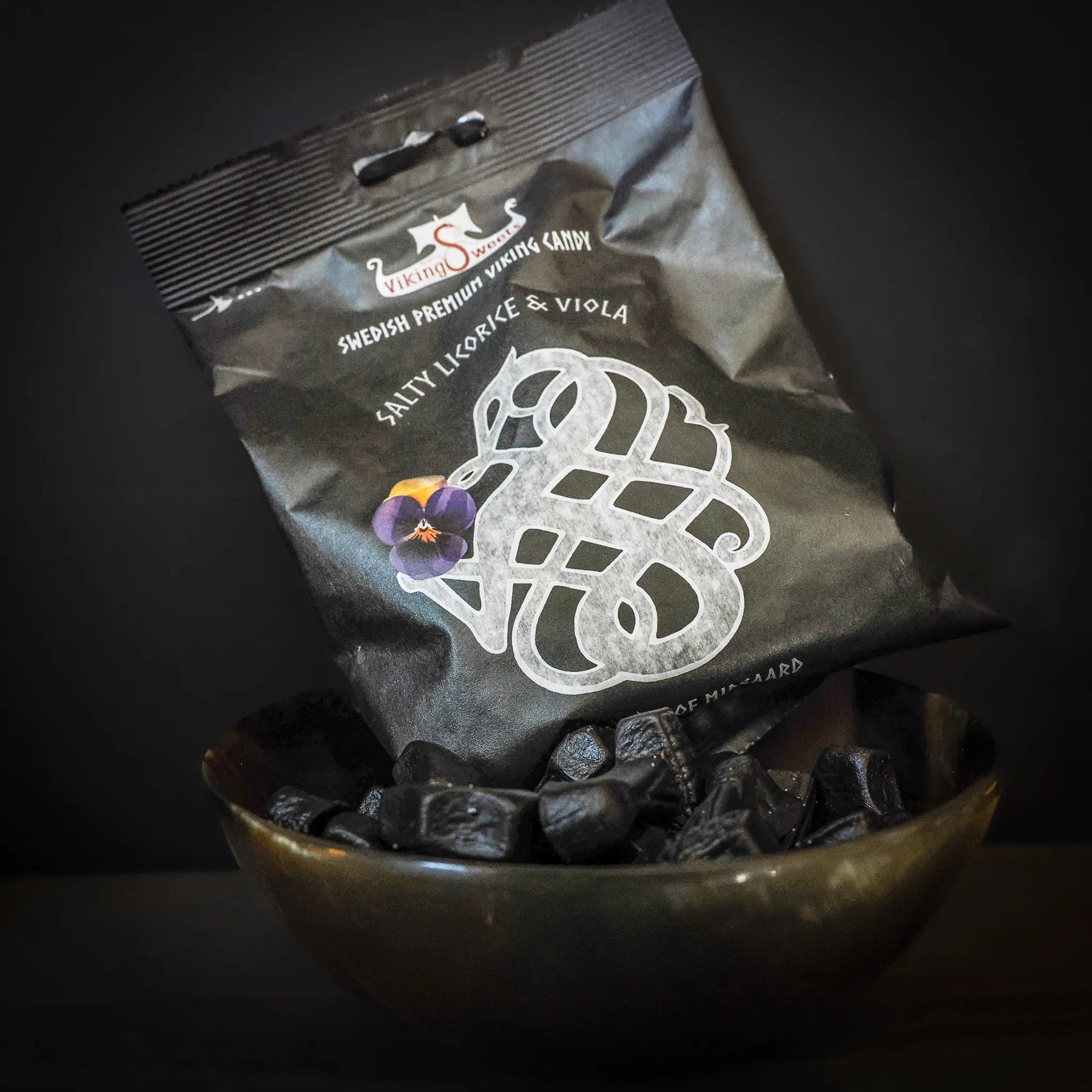 Viking Sweets lakrits med godisbitar på mörk bakgrund. Visar den nordiska sköldsformgivningen på förpackningen.