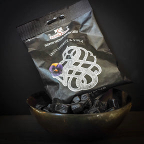 Viking Sweets lakrits med godisbitar på mörk bakgrund. Visar den nordiska sköldsformgivningen på förpackningen.