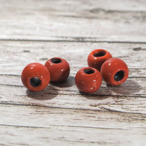 Röda glaspärlor i närbild på trä, detaljfoto med glansig finish