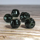 Mörkgrön melonpärla i mindre storlek, 6mm med 2mm hål. Translucent djupgrön glasyrta med blank finish. Fem exemplar visar pärlans rotationsgeometri på ljus bakgrund.
