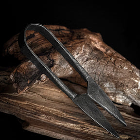 Large herb shears – folded, seen at an angle from the side against driftwood