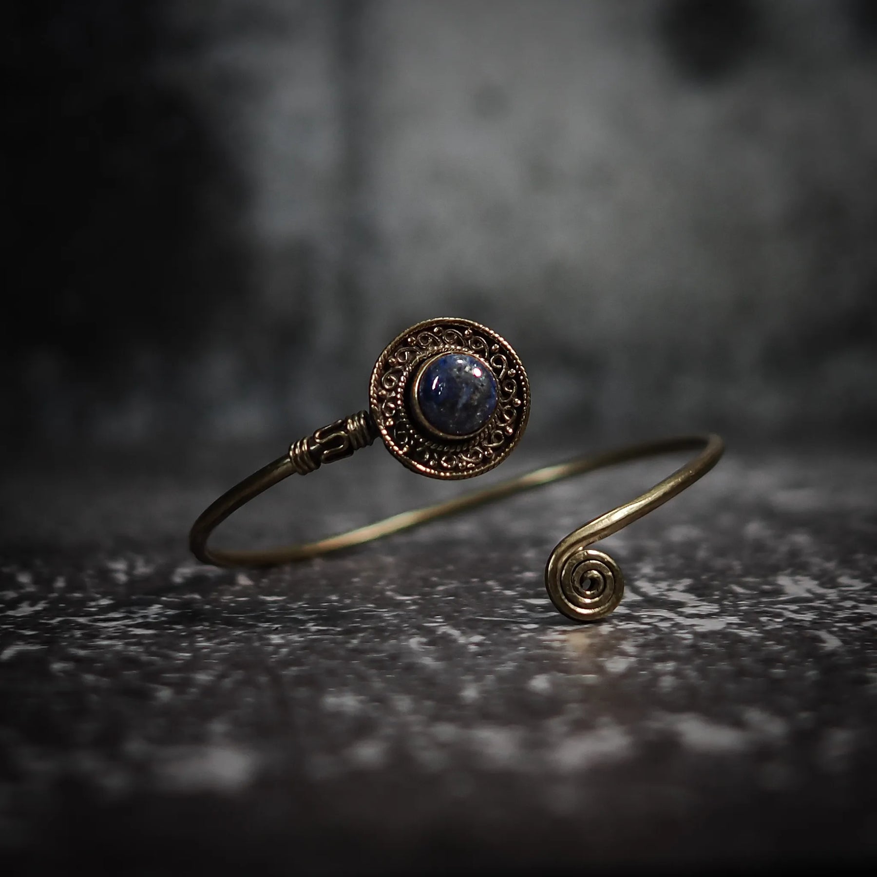 Justerbar armband med mörkblå labradorit sten, dekorativ mässings­behållare och antik-inspirerad filigren-arbete.